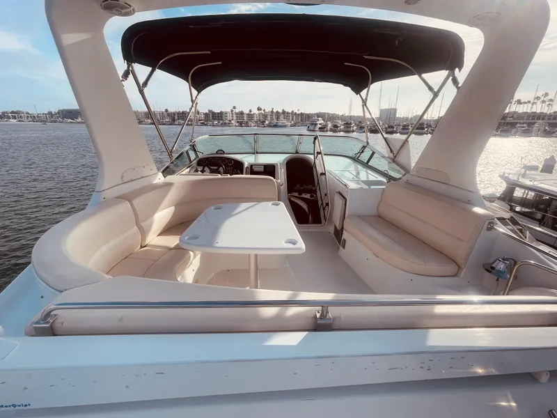 Slide: The Image of 1999 Carver Voyager yacht interior with seating and table, docked by the water. - 7