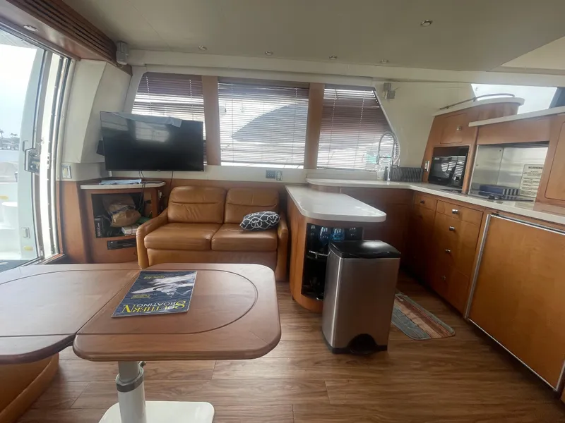 Slide: The Image of Interior of 1999 Carver Voyager yacht with leather seating, kitchenette, and TV. - 15