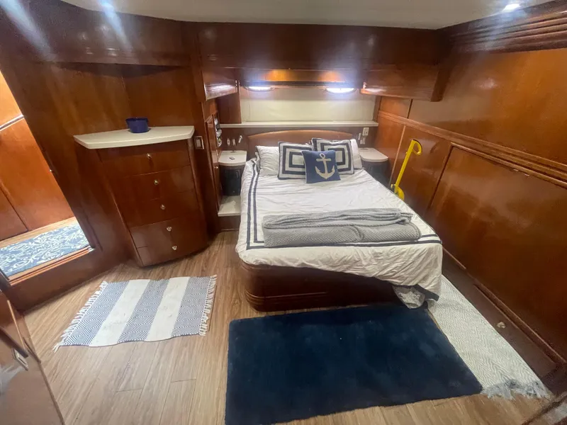 Slide: The Image of Luxurious 1999 Carver Voyager cabin with wood paneling and cozy bedding. - 26