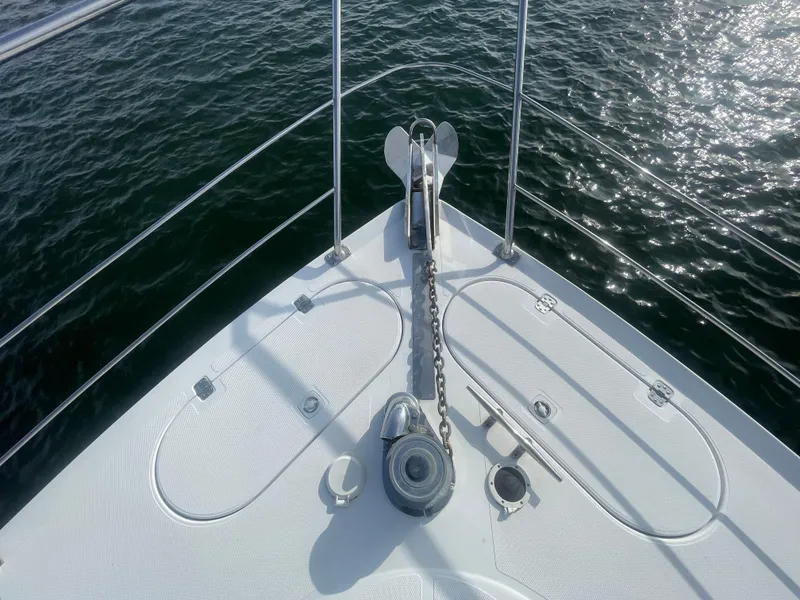 Slide: The Image of Bow of 1999 Carver Voyager yacht with anchor chain over water. - 3
