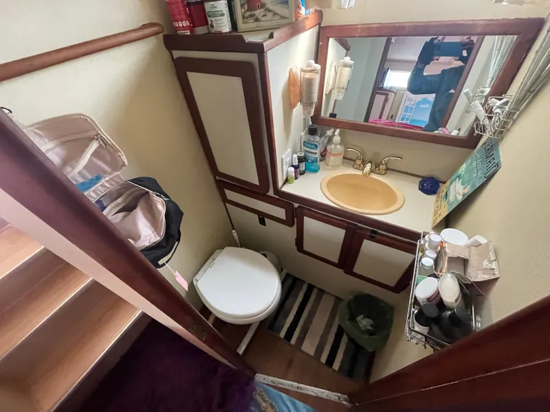 Slide: The Image of 1984 Uniflite Double Cabin Motor Yacht bathroom with sink, mirror, and storage. - 11