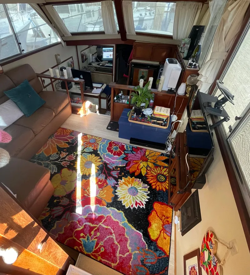Slide: The Image of 1984 Uniflite Double Cabin Motor Yacht interior with colorful floral rug and cozy seating area. - 12