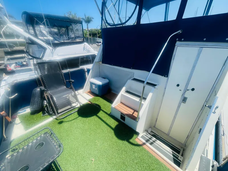 Slide: The Image of 1984 Uniflite Double Cabin Motor Yacht with outdoor seating and artificial grass deck. - 18