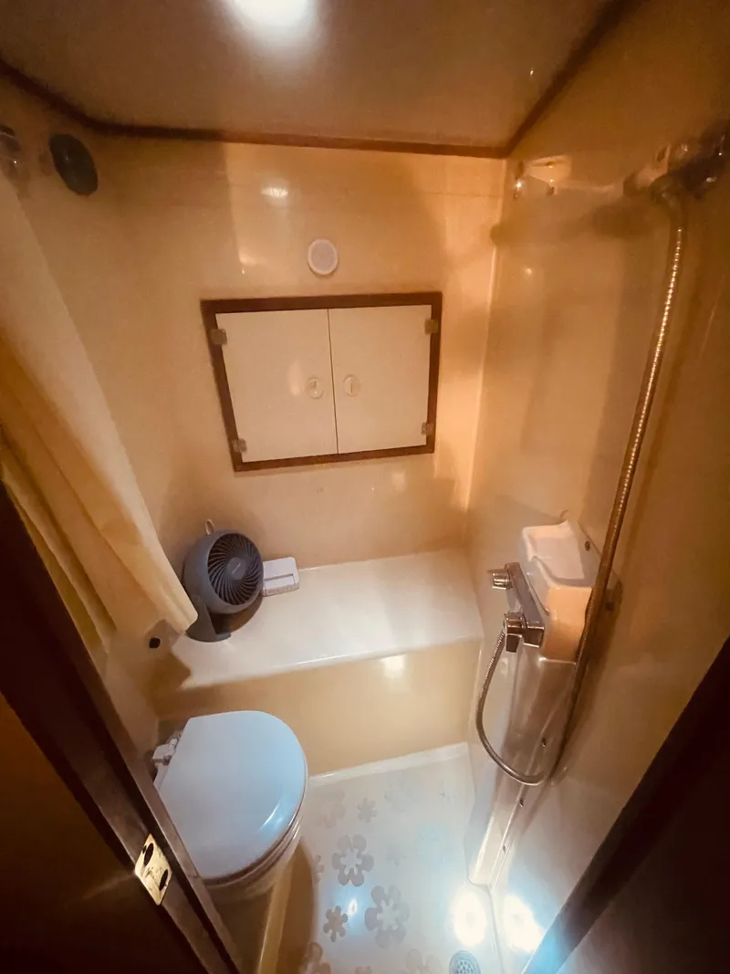Slide: The Image of 1984 Uniflite Double Cabin Motor Yacht bathroom with shower, toilet, and storage cabinet. - 27