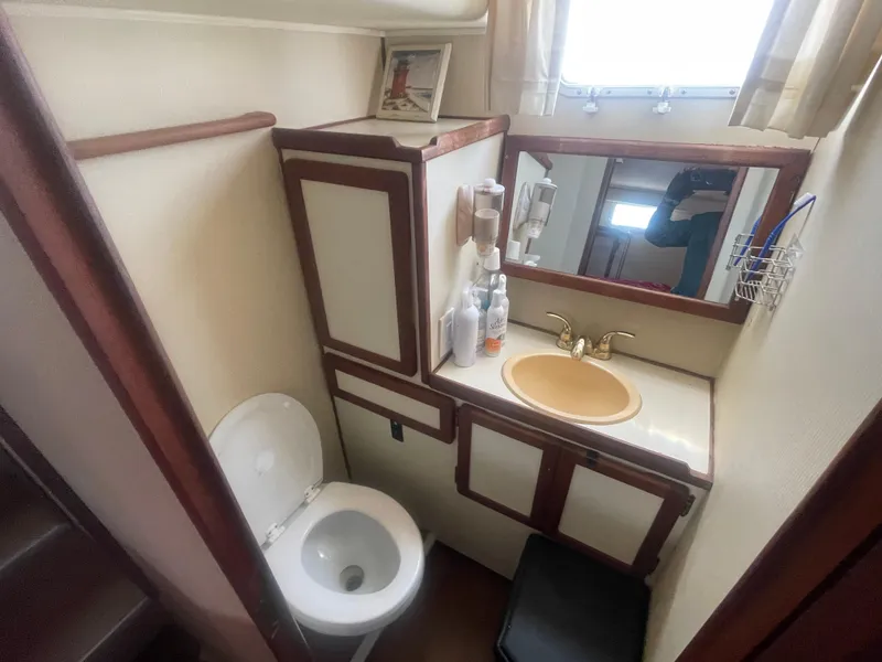 Slide: The Image of 1984 Uniflite Double Cabin Motor Yacht bathroom with sink, toilet, and mirror. - 33