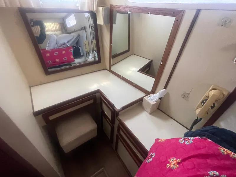 Slide: The Image of 1984 Uniflite Double Cabin Motor Yacht interior with vanity, mirrors, and seating. - 34