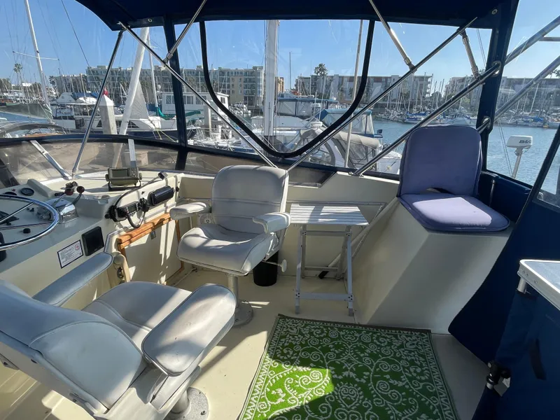 Slide: The Image of 1984 Uniflite Double Cabin Motor Yacht interior with helm, seating, and marina view. - 6