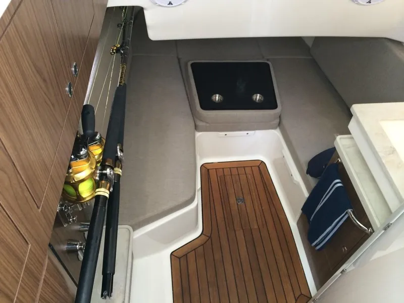 Slide: The Image of Interior cabin of 2023 Boston Whaler 380 Outrage with fishing rods and wooden flooring. - 13