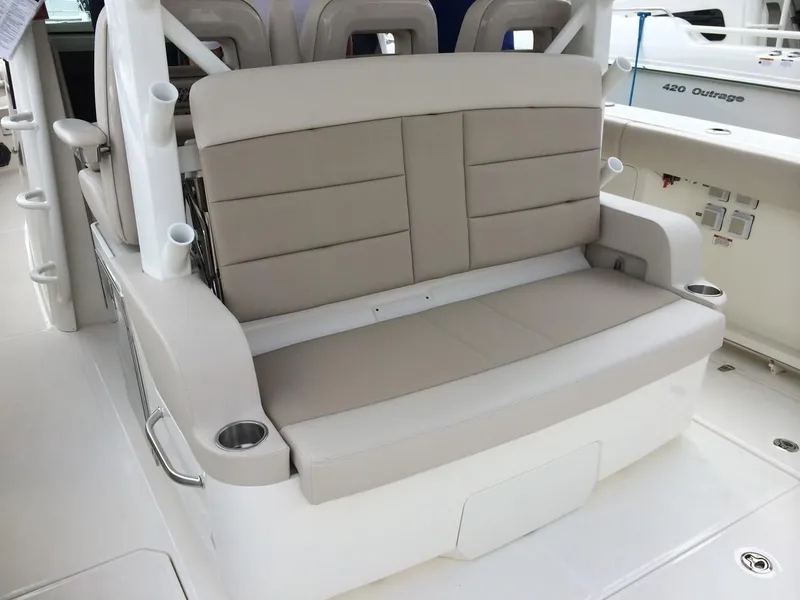 Slide: The Image of 2023 Boston Whaler 380 Outrage boat seating area with beige cushions and cup holders. - 8