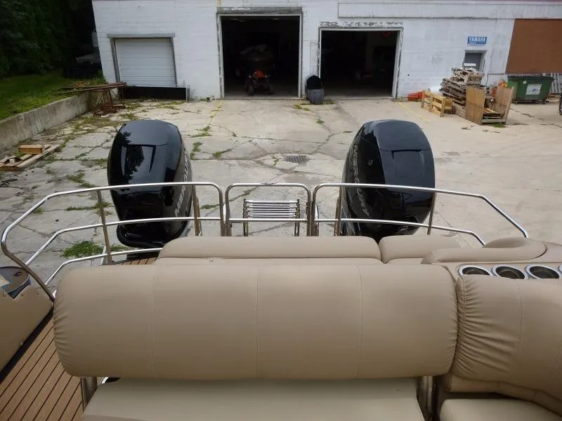 Slide: The Image of 2016 Harris Grand Mariner SEL 250 boat with dual outboard motors in a storage yard. - 5