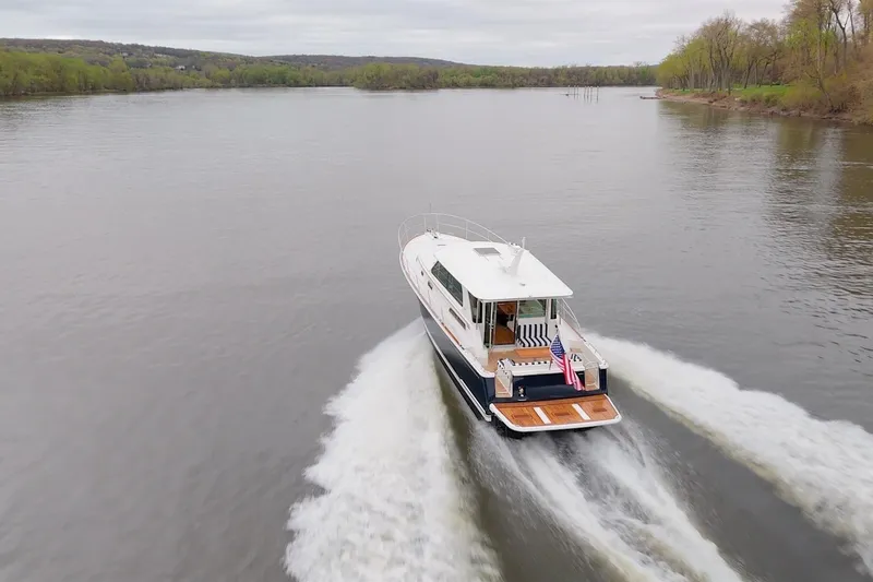 Slide: The Image of 2026 Sabre 45 Salon Express cruising on a serene river with lush green banks. - 10