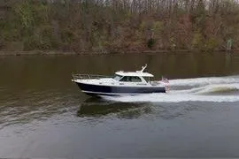 Slide: The Image of 2026 Sabre 45 Salon Express cruising on a calm river with forested banks. - 11