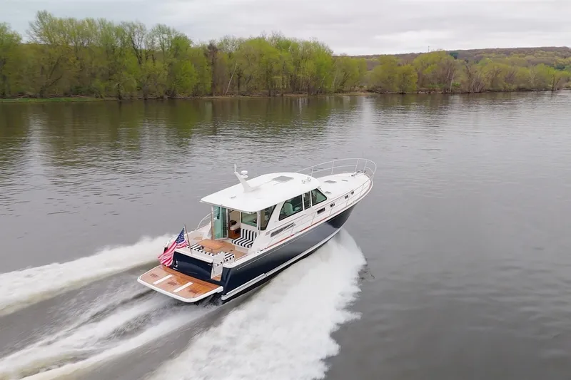 Slide: The Image of 2026 Sabre 45 Salon Express cruising on a serene river with lush green trees. - 9