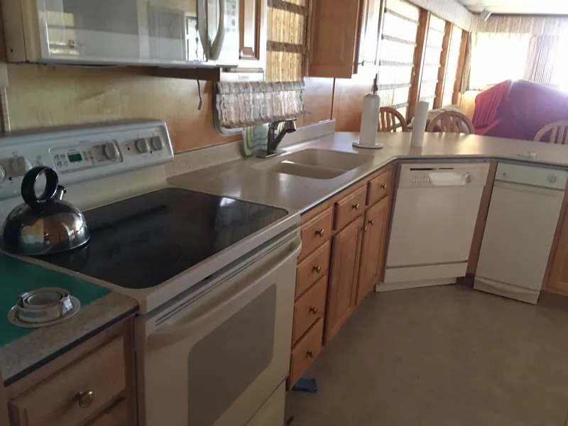 Slide: The Image of Modern kitchen with wooden cabinets, stove, dishwasher, and microwave in a 2002 Sharpe model. - 10