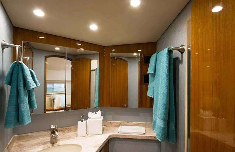 Slide: The Image of Luxurious bathroom in 2025 Viking 44 Open Express yacht with modern fixtures and teal towels. - 11