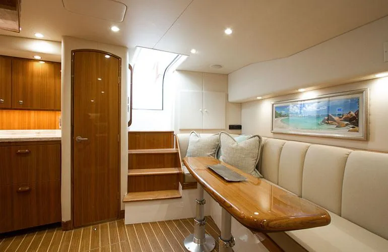 Slide: The Image of Interior of 2025 Viking 44 Open Express yacht with wooden finishes and cozy seating area. - 8
