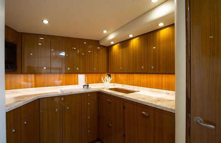 Slide: The Image of Luxurious kitchen interior of 2025 Viking 44 Open Express yacht with wooden cabinets and marble countertops. - 9