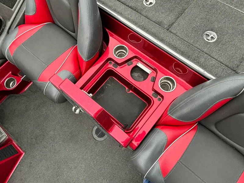 Slide: The Image of 2016 Ranger Z520 boat interior with red and black seats, cup holders, and storage compartment. - 8