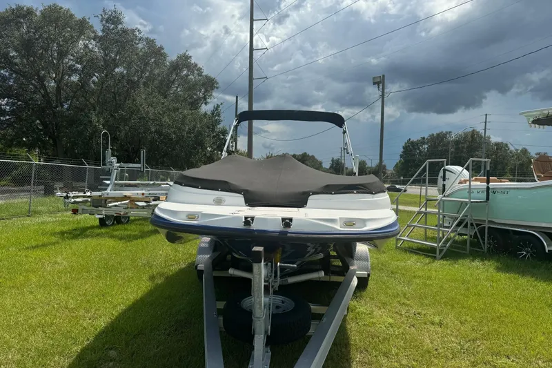 Slide: The Image of 2022 Starcraft Limited 2000 OB Fish boat on trailer, parked on grass under cloudy sky. - 8