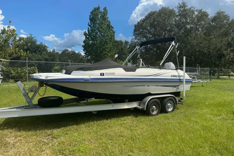 Slide: The Image of 2022 Starcraft Limited 2000 OB Fish boat on trailer, parked on grass. - 6