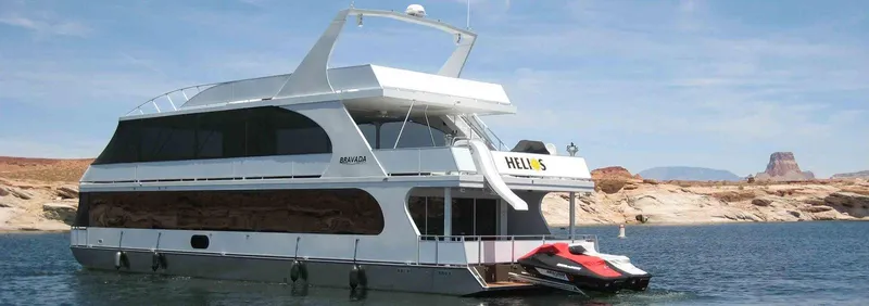 The Image of 2012 Bravada Helios Share #1 houseboat on a serene lake with a jet ski. - 0