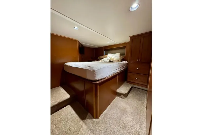 Slide: The Image of Cozy bedroom interior in 2012 Bravada Helios Trip #7 houseboat, featuring a raised bed and wooden cabinetry. - 12