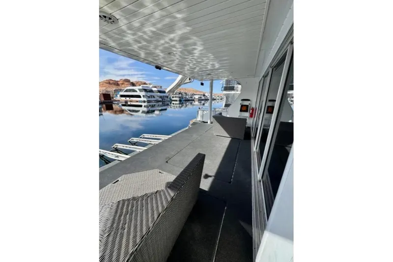 Slide: The Image of Houseboat deck view with seating, reflecting water, and docked boats; Bravada Helios Trip #7, 2012. - 20