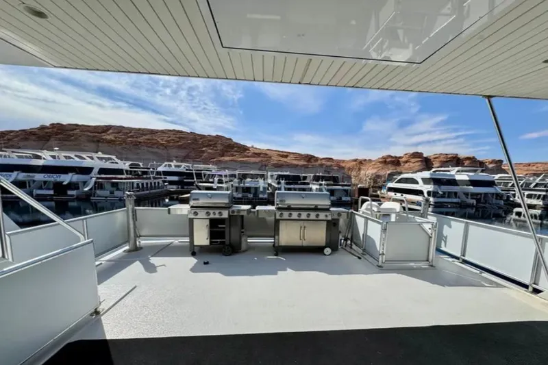 Slide: The Image of Outdoor deck with grills on Bravada Helios Trip #7, surrounded by houseboats and rocky landscape. - 28