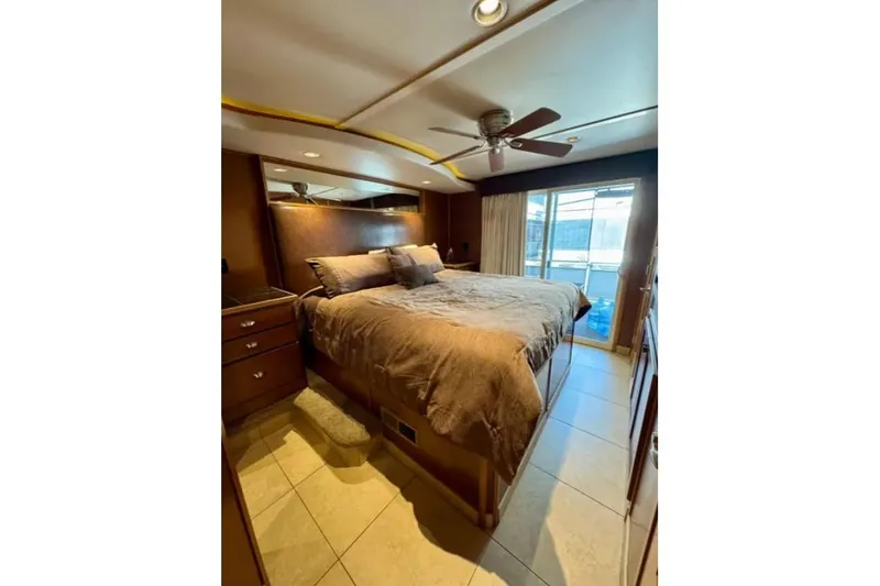 Slide: The Image of Luxurious bedroom interior in 2012 Bravada Helios Trip #7 houseboat, featuring a cozy bed and ceiling fan. - 3