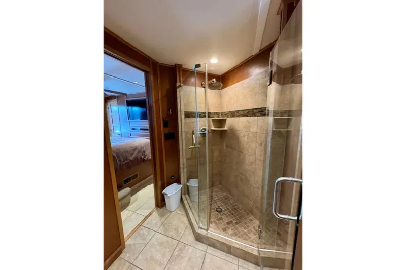 Slide: The Image of Luxurious shower in 2012 Bravada Helios Trip #7, featuring glass doors and tiled interior. - 7