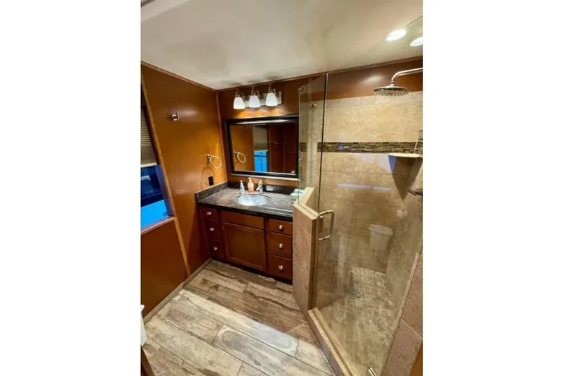 Slide: The Image of Luxurious bathroom in 2012 Bravada Helios Trip #7, featuring glass shower and wooden cabinetry. - 9