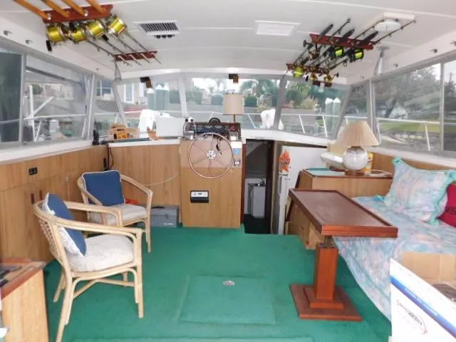 Slide: The Image of Interior of a 1976 Bertram 42 Convertible boat with fishing rods and seating area. - 10