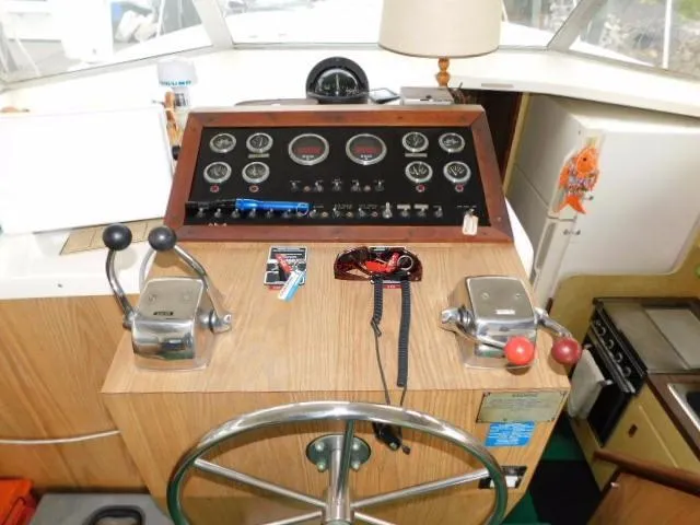 Slide: The Image of 1976 Bertram 42 Convertible helm with gauges, controls, and steering wheel. - 12