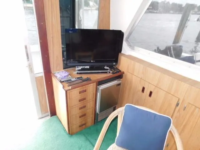 Slide: The Image of Interior of a 1976 Bertram 42 Convertible with TV, mini-fridge, and wooden cabinetry. - 14