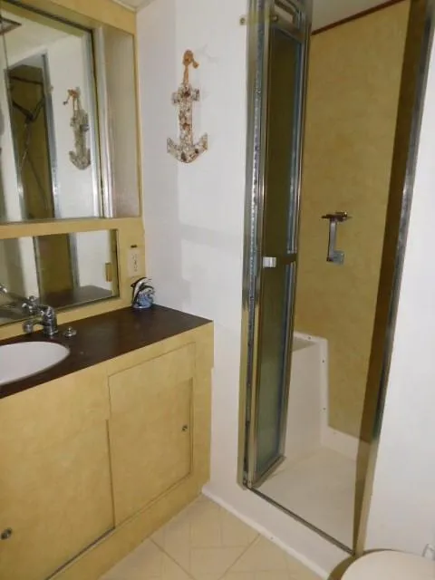 Slide: The Image of 1976 Bertram 42 Convertible bathroom with shower, sink, and anchor wall decor. - 20