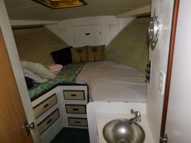 Slide: The Image of 1976 Bertram 42 Convertible cabin with bed, storage drawers, and small sink. - 22