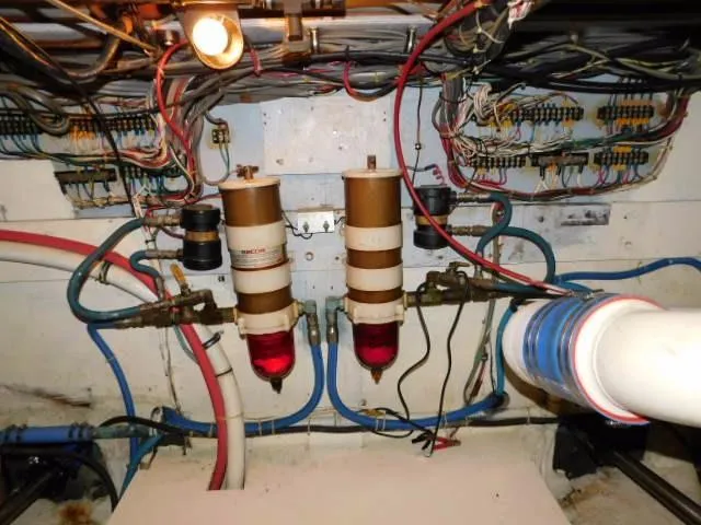 Slide: The Image of Engine room of a 1976 Bertram 42 Convertible with wiring and fuel filters. - 23