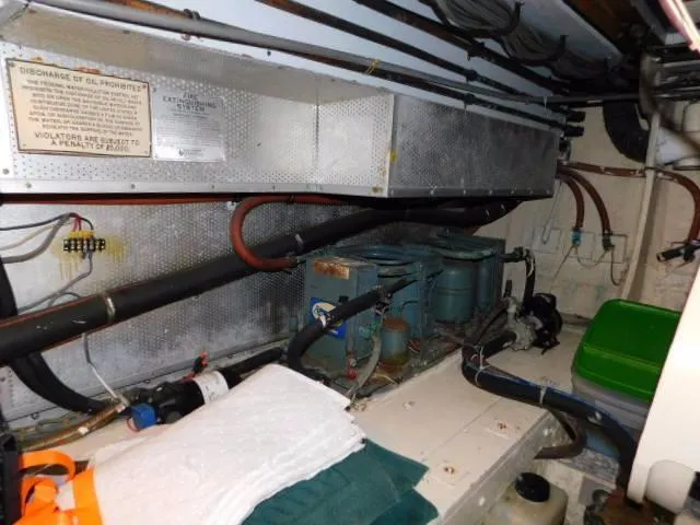 Slide: The Image of Engine room of a 1976 Bertram 42 Convertible boat with visible machinery and pipes. - 27