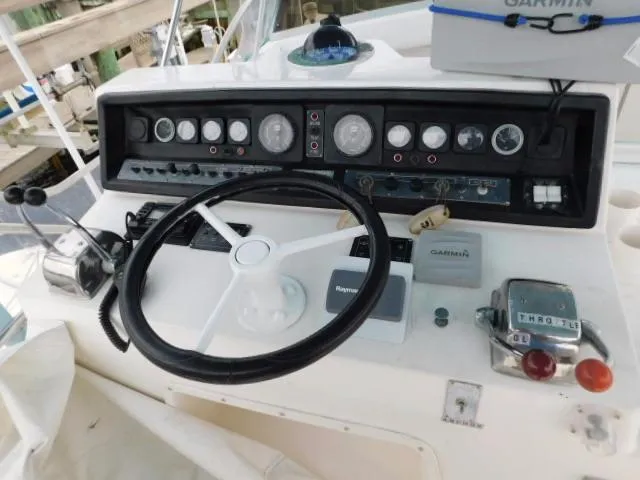 Slide: The Image of 1976 Bertram 42 Convertible boat dashboard with steering wheel and control panel. - 33