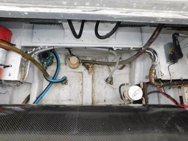 Slide: The Image of Engine compartment of a 1976 Bertram 42 Convertible boat, showing hoses and mechanical components. - 4