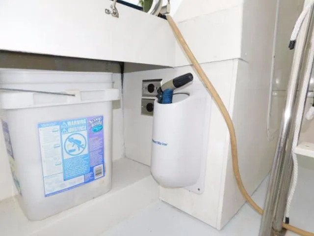 Slide: The Image of 1976 Bertram 42 Convertible interior with cleaning supplies and hose storage. - 9