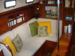 Slide: The Image of Interior of 1983 Whitby 42 sailboat with cozy seating and bookshelf. - 13