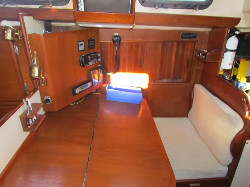 Slide: The Image of Navigation station of a 1983 Whitby 42 sailboat with wooden desk and seating. - 16