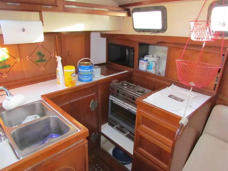 Slide: The Image of 1983 Whitby 42 sailboat galley with sink, stove, and storage. - 21