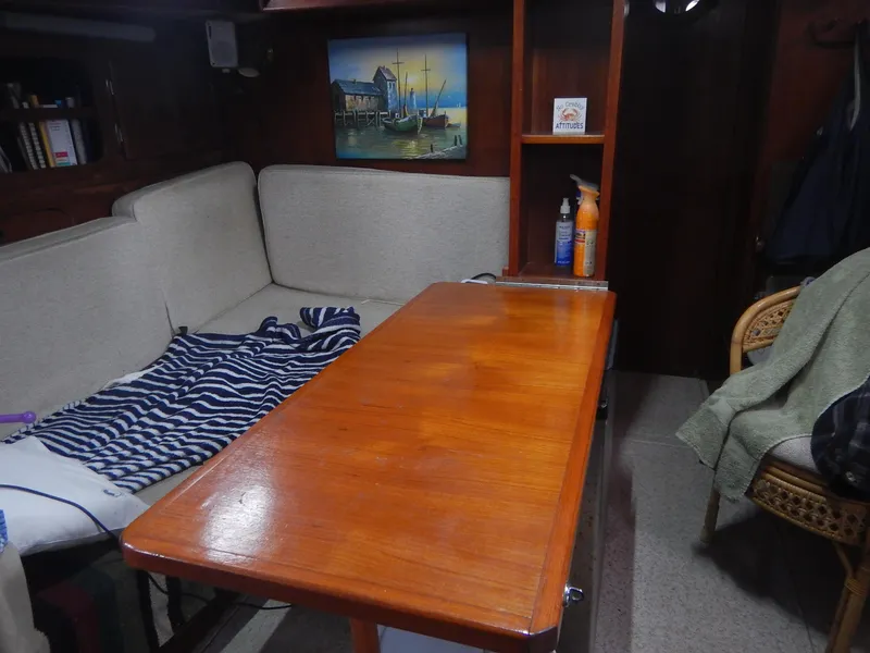 Slide: The Image of Interior of 1983 Whitby 42 sailboat with wooden table and cozy seating area. - 28
