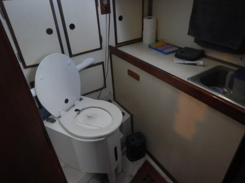 Slide: The Image of 1983 Whitby 42 boat bathroom with toilet, sink, and storage cabinets. - 29