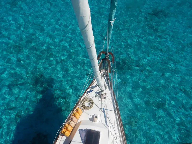 Slide: The Image of Aerial view of 1983 Whitby 42 sailboat on clear turquoise water. - 6
