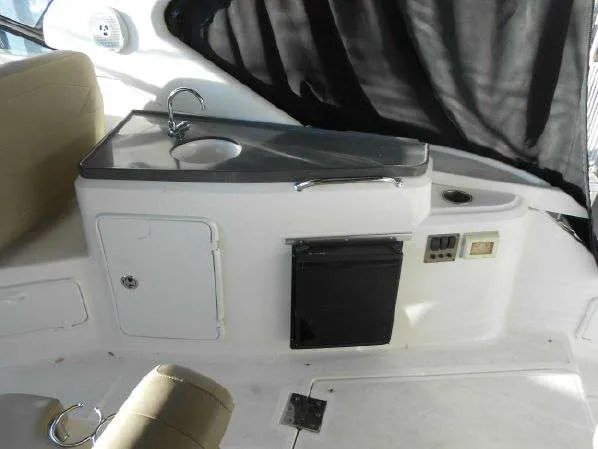Slide: The Image of 2013 Regal 35 Express Cruiser interior kitchenette with sink and mini-fridge. - 16