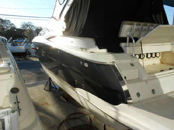 Slide: The Image of 2013 Regal 35 Express Cruiser boat docked, black and white exterior, rear view. - 21