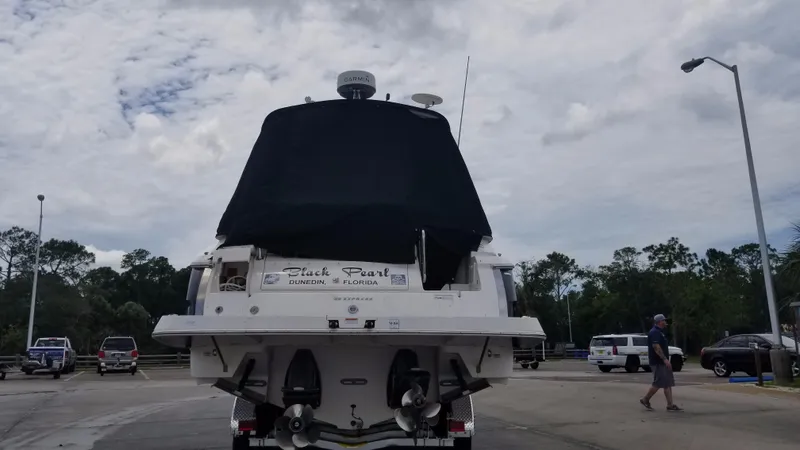Slide: The Image of 2013 Regal 35 Express Cruiser boat on trailer, rear view, covered, in parking lot. - 39